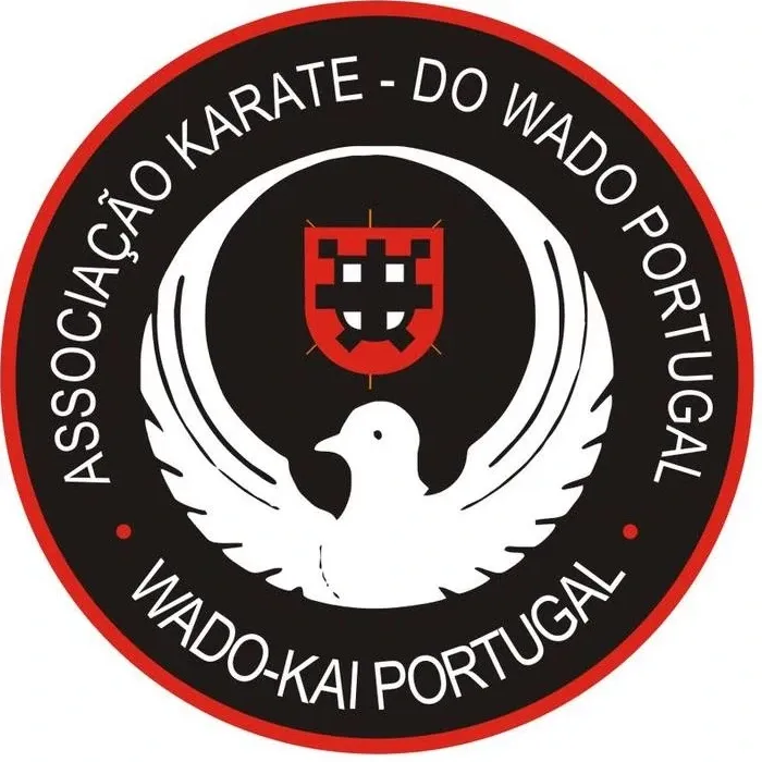Emblema da Associação Karate-do Wado Portugal: uma pomba branca de asas abertas sob o escudo português, num disco negro com orla vermelha